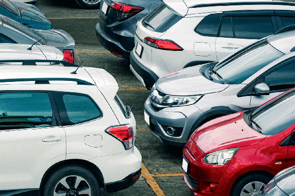 Image of several cars of varying colors parked in a row